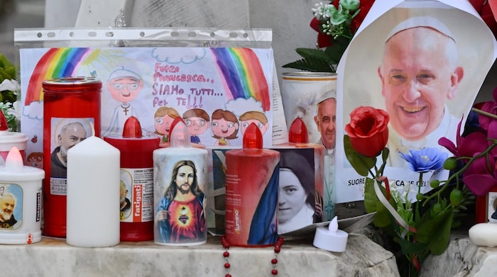 Vor dem Spital, in dem der Papst behandelt wird, haben Menschen Kerzen, Blumen und Bilder ...