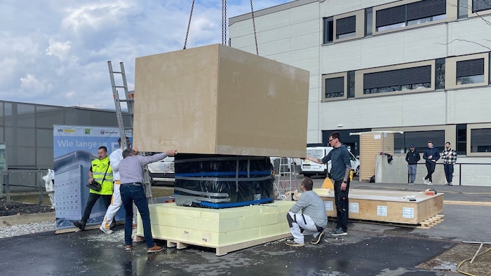 Die Hülle in Modulbauweise wird über den Eisblock gehoben