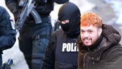 Frankreichs „Staatsfeind Nummer 1“ Mohamed Amra mit einem Grinser bei seiner Festnahme. (Bild: APA/AFP/Daniel MIHAILESCU)