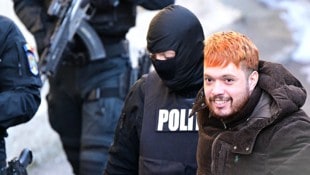 Frankreichs „Staatsfeind Nummer 1“ Mohamed Amra mit einem Grinser bei seiner Festnahme. (Bild: APA/AFP/Daniel MIHAILESCU)