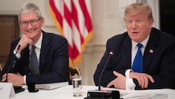 Auf diesem Foto hat Apple-Chef Tim Cook noch gut lachen, doch der Druck durch Trump auf den Konzern, in den USA zu fertigen, steigt. (Bild: AFP)