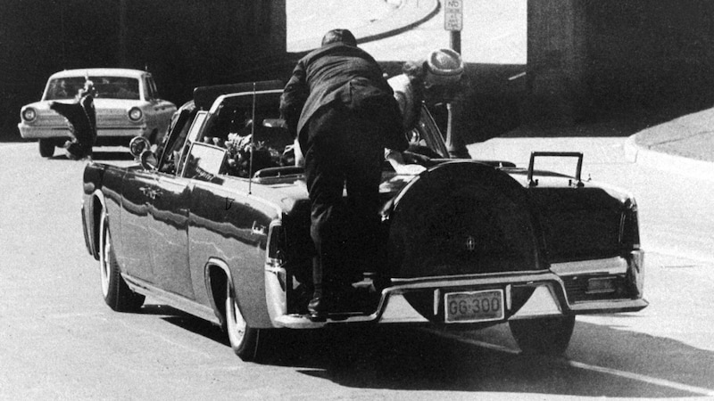 "First Lady Jacqueline Kennedy bends over the fatally shot President John F. Kennedy in Dallas on November 22, 1963, as Secret Service agent Clint Hill pushes her back into her seat and lies protectively over her. (Bild: AP)