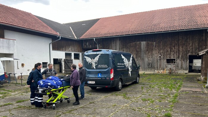 Auf einer Fahrtrage wurde der Altbauer langsam durch seinen Hof gefahren.