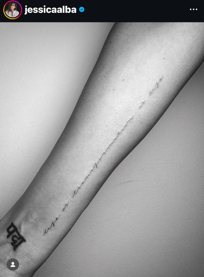 "Life is change is life" is written in cursive on her forearm.