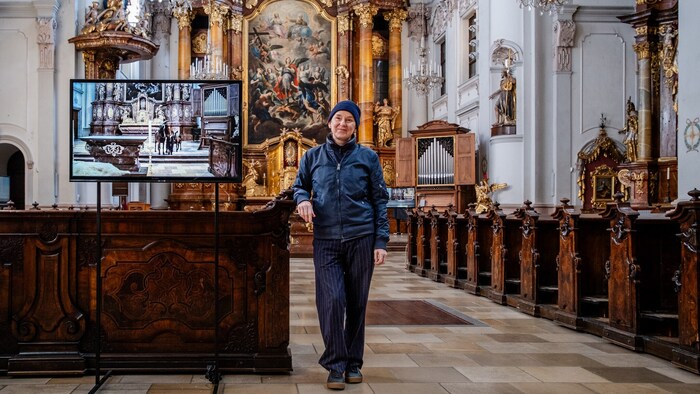 Nicole Six next to the monitor in the Ursuline Church, showing the film with the animals.