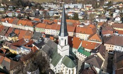 Sehr hoch und zur Länge der Kirche unproportional wirkt der Turm der Stadtpfarrkirche St. Veit ...