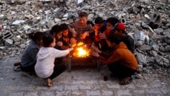 Palästinensische Kinder wärmen sich bei einem Lagerfeuer im Bureidsch-Flüchtlingscamp. (Bild: APA/AFP or licensors)