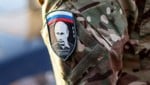 Ein russischer Soldat trägt das Portrait von Putin auf seinem Arm.