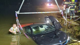 Dem Feuerwehrmann im eisigen Teich war sichtlich kalt, als er den versunkenen BMW-Hybrid ...
