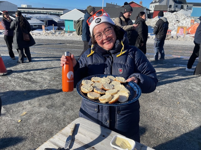 Aktivistin der Liste Naleraq verteilt Butterbrote an Unschlüssige.