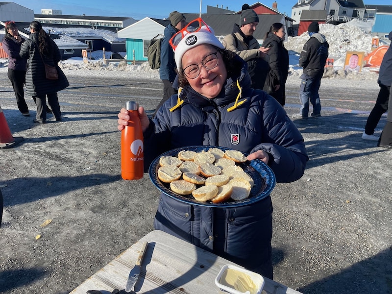 Aktivistin der Liste Naleraq verteilt Butterbrote an Unschlüssige. (Bild: Gregor Brandl)