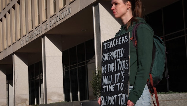 A demonstrator protests against the massive job cuts outside the headquarters of the US Department of Education in Washington. (Bild: WIN MCNAMEE)