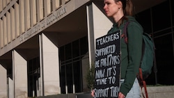 Eine Demonstrantin protestiert vor dem Hauptsitz des US-Bildungsministeriums in Washington gegen den massiven Stellenabbau. (Bild: AFP/WIN MCNAMEE)