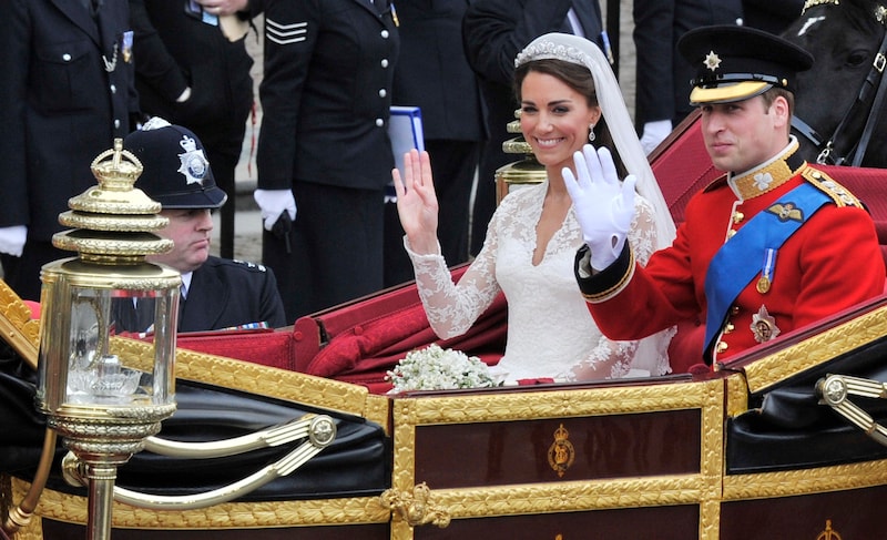 Prinz William und seine Braut Catherine bei ihrer –typischen – royalen Hochzeit, inklusive Kutschenfahrt und freundlichem Winken.  (Bild: Boris Roessler / dpa / picturedesk.com)