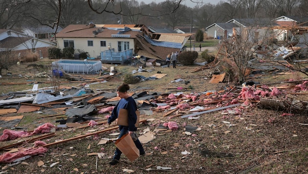 Missy sucht nach einem schweren Sturm in Bridgeton, Missouri, in dem Trümmerfeld nach Fotos. (Bild: APA/ASSOCIATED PRESS)