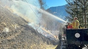 Der Hang wird abgebrannt und danach bewässert, damit sich die Flammen nicht zu weit ausbreiten.