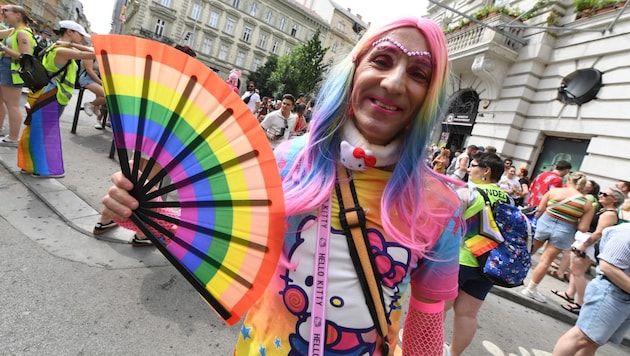 A participant poses with a fan in rainbow colors during the Pride parade in Budapest last summer. The event is soon to be history in Hungary. (Bild: AFP)