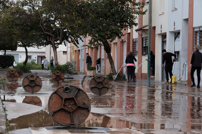 Anwohner befreien die Straßen von Schlamm nach schweren Regenfällen in Campanillas, Málaga. (Bild: AP/Gregorio Marrero)