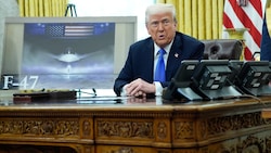 US-Präsident Donald Trump präsentiert eine Illustration des neuen Jets. (Bild: EPA/YURI GRIPAS / POOL)