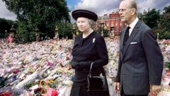 Königin Elisabeth II. und ihr Prinzgemahl. Im Hintergrund: Blumen, die vor Dianas Londoner Wohnsitz Kensington Palace abgelegt wurden. (Bild: Krone KREATIV/APA Picturedesk)