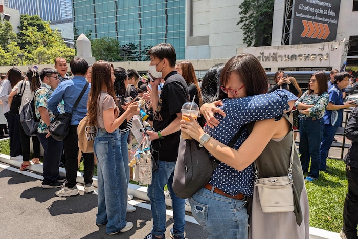 Menschen in Bangkok stehen unter Schock, liegen sich in den Armen. 