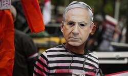 Ein Demonstrant im Gefangenenkostüm und Netanyahu-Maske