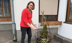 Martina Reiter beim schmiedeeisernen Gestell vor ihrem Haus, in dem sich der Kupferkessel ...
