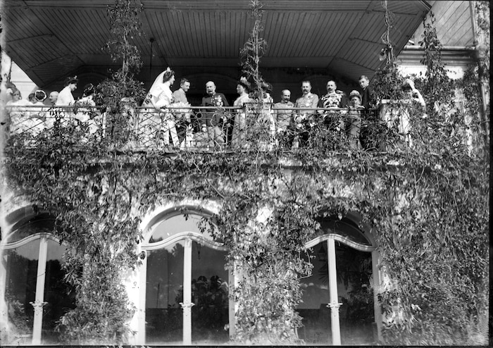 Vom Balkon des Schlosses aus winkt die kaiserliche Familie den Schaulustigen zu.