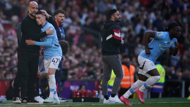 Pep Guardiola (li.) umarmt Phil Foden nach dessen Auswechslung.  (Bild: AP/Dave Thompson)