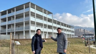 Wohnbaureferent Jürgen Jöbstl und Stadtvize Alexander Radl bei den vier neuen Gebäuden in Kirchbichl. Die Erstmieter haben ihre Schlüssel erhalten. (Bild: Stadtpresse Wolfsberg)