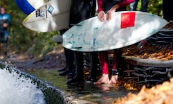 Surfer bei der Eisbachwelle in München