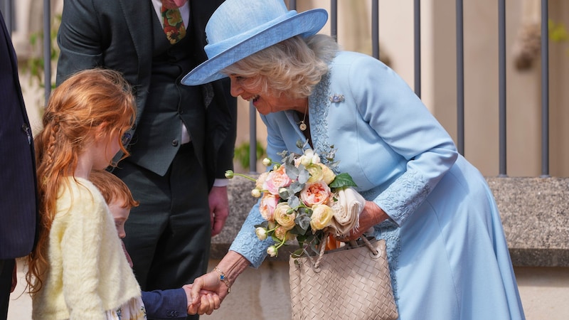 Königin Camilla freute sich über Blumen, die sie von zwei Kindern überreicht bekommen hatte. (Bild: AP/Kirsty Wigglesworth, Pool)