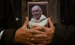 Eine Katholikin hält ein Bild des Papstes in den Händen, als sie nach seinem Tod die Messe ...