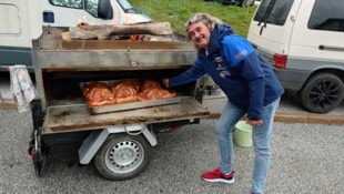 Fritz zeigt stolz die drei Schweinebäuche, die vor sich hin braten (Bild: Michael Höller)