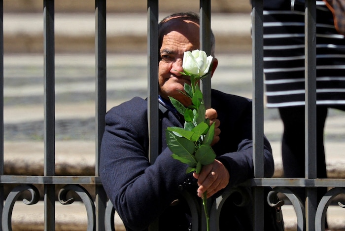Eine Obdachlose wartet mit einer weißen Rose