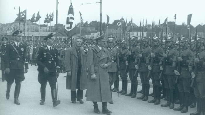 August Eigruber links hinter Adolf Hitler 1938 in Linz