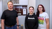 Familie G. vor ihrem Sicherungskasten mit dem neuen Smart Meter