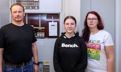 Familie G. vor ihrem Sicherungskasten mit dem neuen Smart Meter