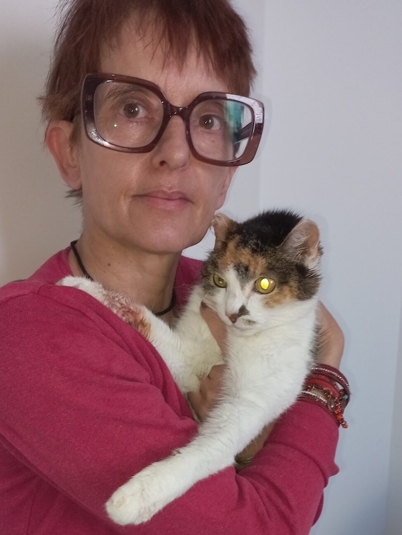 Frau K. mit ihrer „Kitty“. Die ansonsten weiße Pfote ist blutverschmiert, da die Katze ständig versuchte ihr Ohr zu putzen. (Bild: privat)