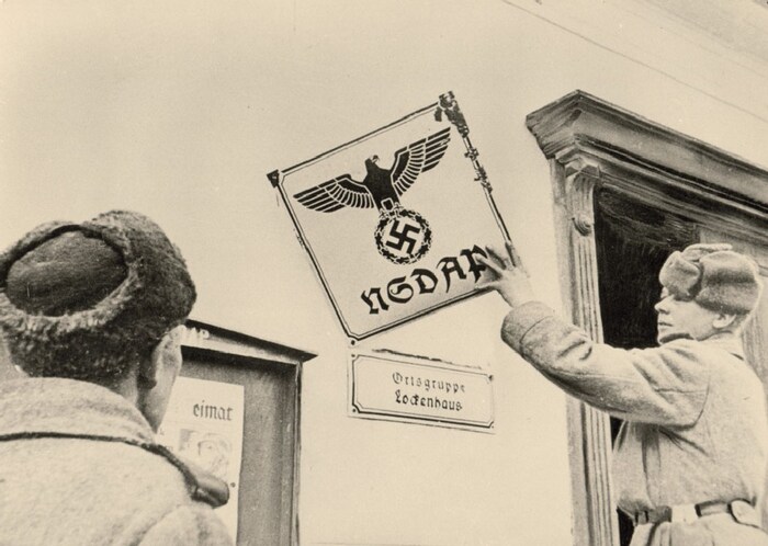 Ein sowjetischer Soldat entfernt NS-Schild in Lockenhaus.