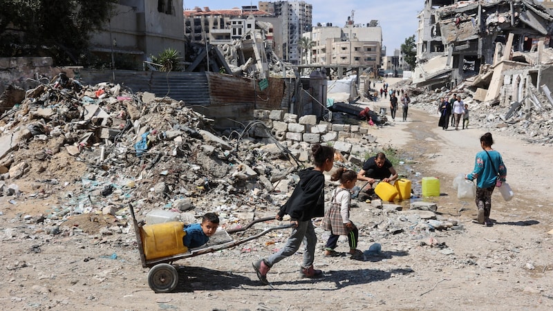 Palästinensische Kinder auf dem Weg zu einer Wasserausgabestelle in Gaza-Stadt (Bild: APA/Omar AL-QATTAA / AFP)