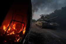 Ein ukrainischer Panzer fährt nahe der russischen Grenze an einem brennenden Fahrzeug vorbei. (Bild: AP/Evgeniy Maloletka)