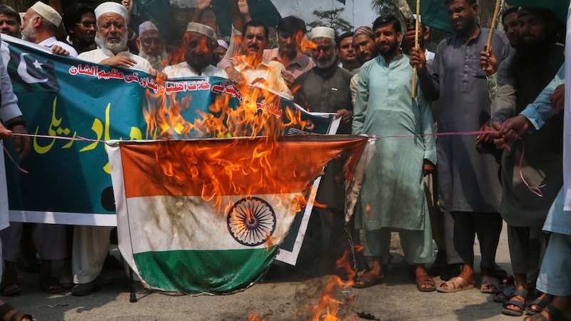 Während eines Protests in Pakistan, bei dem die indischen Angriffe verurteilt werden, wird eine Flagge Indiens verbrannt. (Bild: APA/Associated Press)