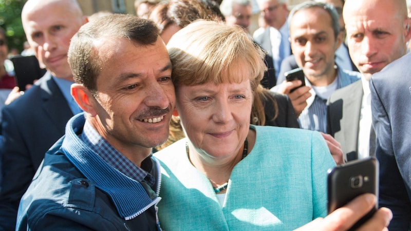 10. September 2015: Die damalige deutsche Bundeskanzlerin Angela Merkel (CDU) lässt sich nach dem Besuch einer Erstaufnahmeeinrichtung für Asylwerber in Berlin für ein Selfie zusammen mit einem Flüchtling fotografieren. (Bild: APA/dpa/Bernd von Jutrczenka)