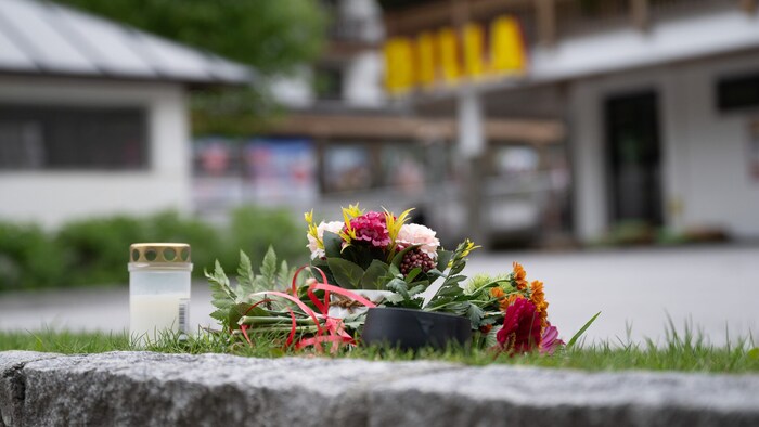 Eine Kerze und Blumen am Tatort in Maria Alm
