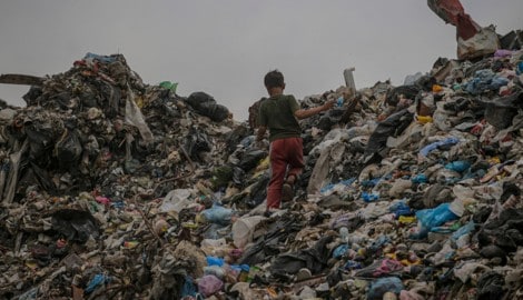 Ein kleines Kind wühlt im Müll.  (Bild: EPA/MOHAMMED SABER)