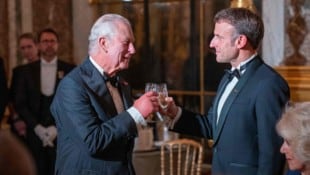 König Charles III. stößt mit dem französischen Präsidenten Emmanuel Macron während eines ...