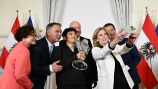Außenministerin Beate Meinl-Reisinger knipst ein gemeinsames Selfie der Regierungsspitze mit Song-Contest-Gewinner JJ.  (Bild: AFP/JOE KLAMAR)