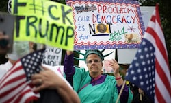 Demonstranten vor dem Golfclub hielten Plakate mit Slogans hoch wie „Stoppt Trumps ...