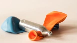 Eine Lachgas-Kapsel und Luftballons – das Rezept für einen kurzen Rausch mit Risiko. (Bild: Corinne - stock.adobe.com)